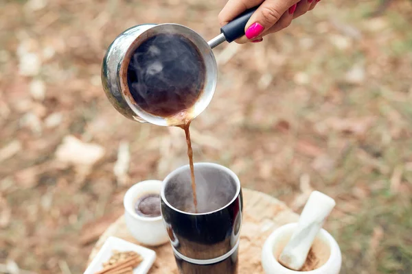 Hot drink on nature. Process of cooking coffee with spices in nature. Background - camping and forest.