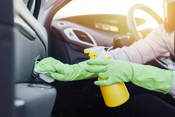 Female hand spraying sanitizer and antiseptic wet wipes for disinfecting car. Cleanliness and healthcare during Corona virus, COVID-19.