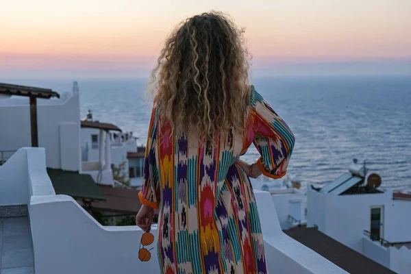 Primer plano de la mujer de la espalda mirando al atardecer y vistas al mar desde la terraza de la villa de vacaciones de lujo —  Fotos de Stock