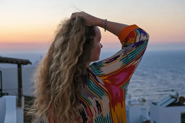 Primer plano de la mujer de la espalda con la mano en el pelo viendo puesta de sol y vistas al mar desde la terraza de la villa de vacaciones de lujo —  Fotos de Stock