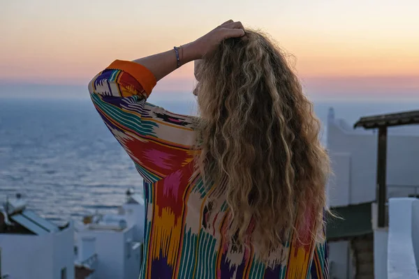 Primer plano de mujer desde atrás disfrutando de la puesta del sol y vistas al mar desde la terraza de la villa de vacaciones de lujo —  Fotos de Stock