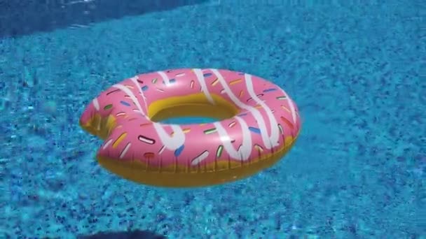 Roze opblaasbare donut drijvend in zwembad 4K — Stockvideo