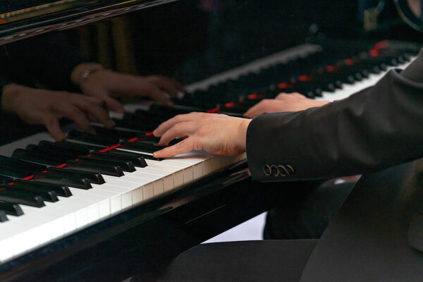 close up of male hands playing piano close up.