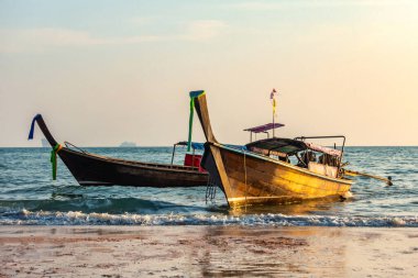 Geleneksel uzun kuyruklu tekneler gün batımında Ao Nang Sahili, Krabi Tayland.