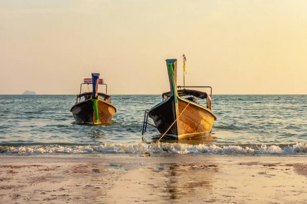 Geleneksel uzun kuyruklu tekneler gün batımında Ao Nang Sahili, Krabi Tayland.