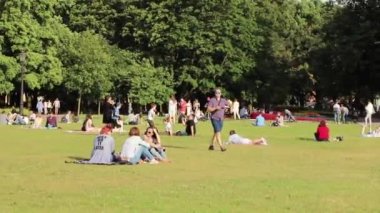 İnsanlar parktaki çimlerin üzerinde dinleniyorlar. Rusya, Saint Petersburg Temmuz 2020