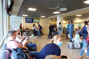 Terminalin kalkış salonundaki yolcular, Pulkovo havaalanının çıkışına. Rusya, Saint Petersburg, Temmuz 2020   