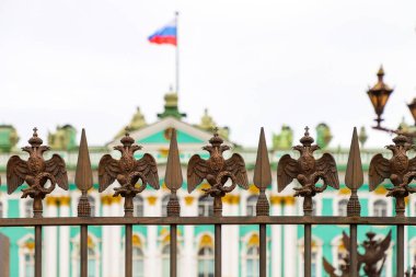 Alexander Sütunu 'nun çitlerinde, yaz günü Kış Sarayı' nın arka planına karşı çift başlı kartallar. Rusya, Saint Petersburg Temmuz 2020