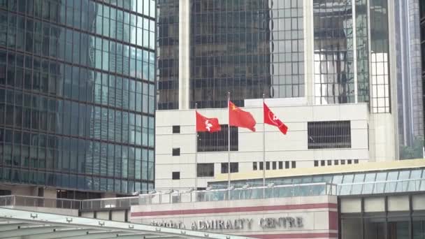 中国和香港的国旗在一个玻璃建筑海事中心的背景下迎风飘扬 中国香港2019年11月 — 图库视频影像