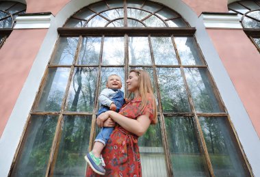 Şirin anne ve oğlu bir büyük cam cephe arka planı. Alt görünümü