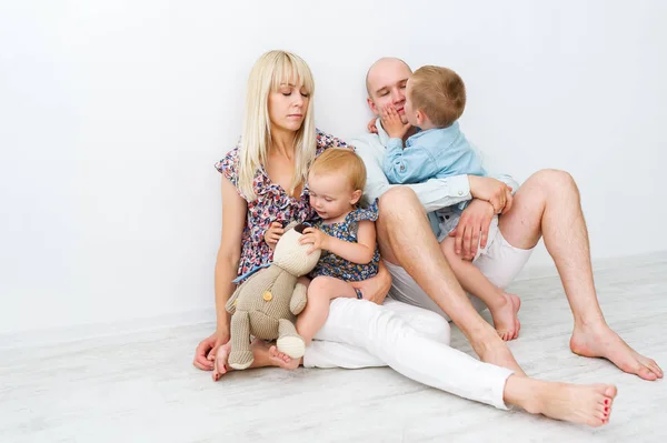 幸せな白人家族が白い背景の上に座っています 幼い息子がキスし 父を包含 — ストック写真