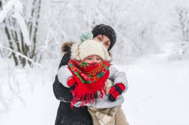 Mutlu bir aile portresi: kış park küçük şirin kızı olan güzel bir kadın vardır.