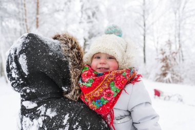 Güzel bir genç kadın küçük sevimli kızıyla birlikte kış park vardır. Portre portre