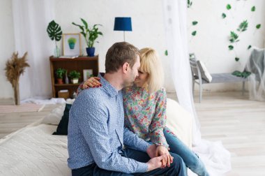 Sarılma ve evde yatakta rahatlatıcı sevgi dolu genç çift.