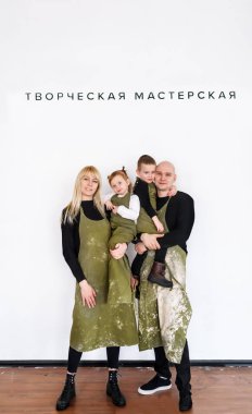 Baba, anne ve çocuk Yeşil önlük. Aile portre yaratıcı bir atölye. Dikey görünüm