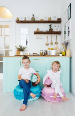 Küçük kız ve erkek kardeşim ev mutfak modeli dondurma ile oturup. Dikey portre