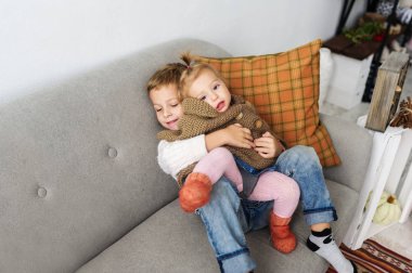 Kardeşi yavaşça küçük kız kardeşi kucaklar. Mutlu çocukluk kavramı