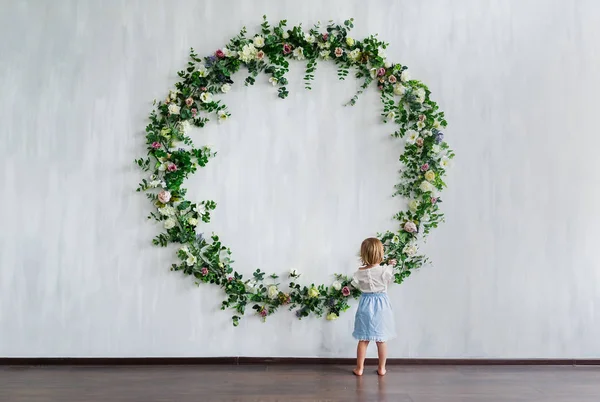 Una Niña Pequeña Parada Cerca Pared Con Grandes Flores Corona — Foto de Stock