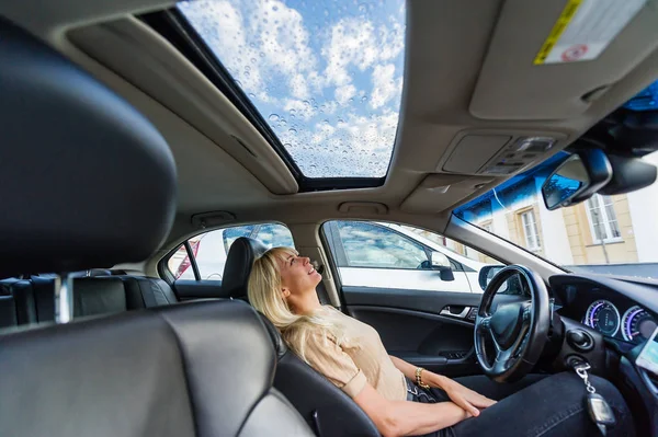 Beautiful Blond Woman Looks Blue Sky Wet Glass Roof Car — Stock Photo, Image