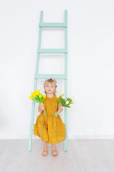 Милая Маленькая Девочка Тюльпанами Находится Светлой Весенней Студии Лестницей Концепция — стоковое фото