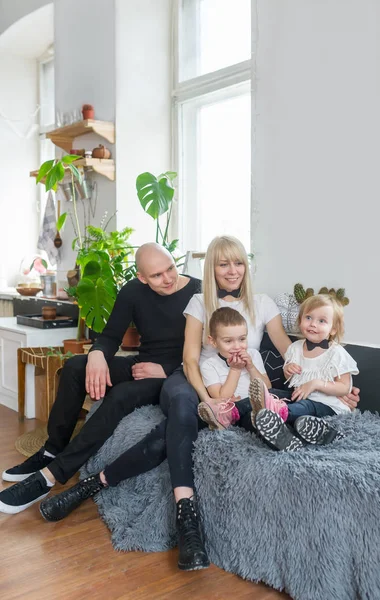 Anne ve iki küçük çocuğu birlikte evde kanepe oturma gülmek. Aile portresi