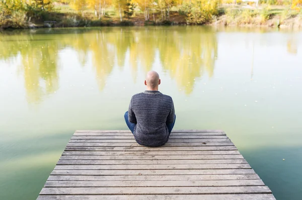 Auf Dem Holzsteg Sitzt Ein Junger Mann Mit Glatze Lotus — Stockfoto