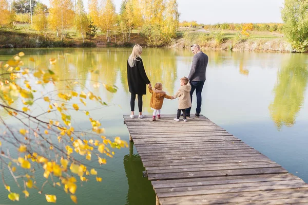 快乐的家庭四站在木码头上 在温暖的秋天的日子 后退视图 — 图库照片