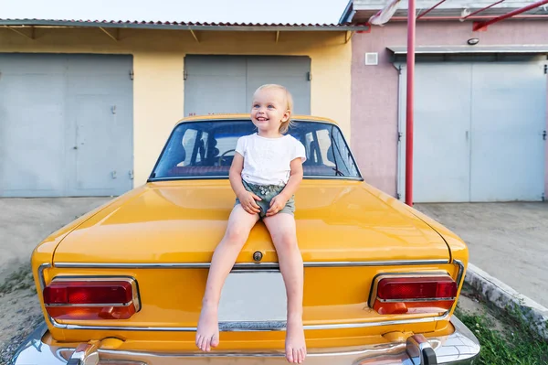 Feliz Niña Sentada Portaequipajes Del Coche Amarillo Durante Día Retrato — Foto de Stock