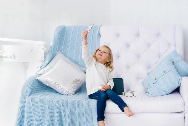 Hermosa Niña Con Estrella Sentada Sofá Una Habitación Blanca Interior — Foto de Stock