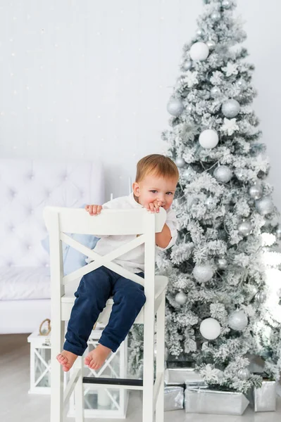 Niño Divertido Sentado Silla Blanca Fondo Del Árbol Navidad Retrato — Foto de Stock