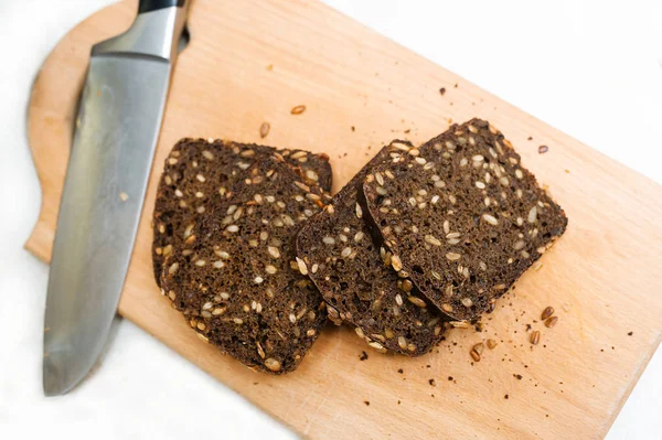 Tohum ile çavdar ekmeği kesme tahtası üzerinde parçalar halinde kesilir. Seçici odak