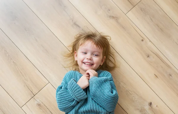 Beautiful Joyful Little Girl Blue Sweater Lies Wood Floor Top — Stock Photo, Image