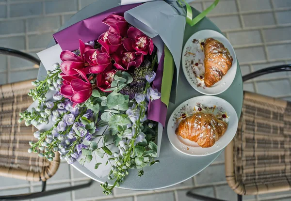 Wedding bouquet with dessert lying on wooden table in bride room.  Top view.