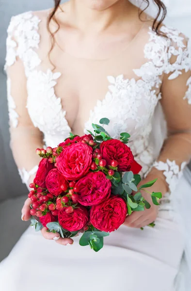 Die Braut hält einen Strauß roter Rosen in der Hand. eleganter Hochzeitsstrauß aus Rosen. — Stockfoto