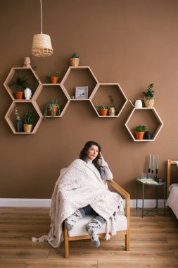 Sevimli kadın daire koltukta oturan bir kitap okuma keyfi