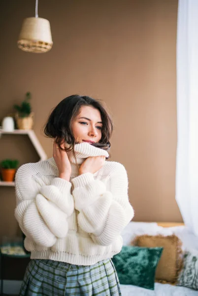 Портрет красивої брюнетки в білому светрі, що розслабляється в приміщенні — стокове фото