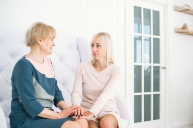 Genç sarışın kadın ve koltukta oturan annesi üst düzey. 