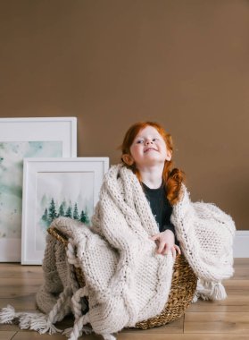 Mutlu küçük Kızıl saçlı kız büyük sepet içinde oturan