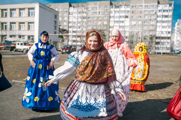 Participants are dressed in traditional Russian clothes of the early 20th century.