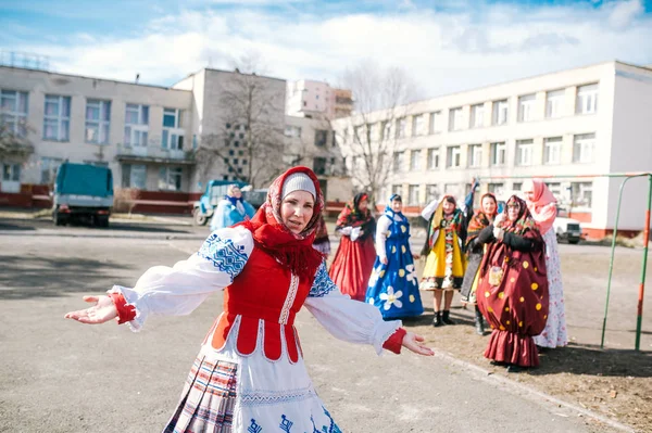 Mujer madura en trajes folclóricos baila en el parque de la ciudad. La celebración del Shrovetide en la ciudad . — Foto de Stock