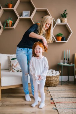 Genç seven anne Redhead çocuk kızı saç fırçalama. Sabah preparatları Lifestyle Concept