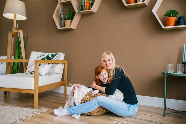 Щаслива молода жінка і її руда дочка сидять на підлозі вдома — стокове фото