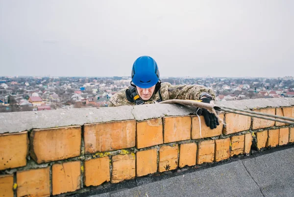 Pendaki industri berseragam dan helm bersiap untuk turun dari gedung pencakar langit — Stok Foto