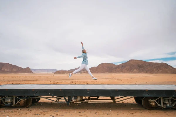 Torów kolejowych na pustyni Wadi Rum w Jordanii. Młoda dziewczyna skacze — Zdjęcie stockowe