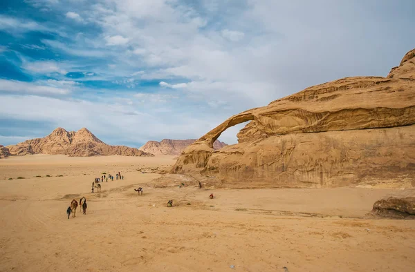 Beduinos no identificados con una caravana de camellos pasea por el desierto de Wadi Rum . — Foto de Stock