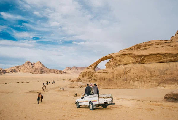Beduinos no identificados con una caravana de camellos pasea por el desierto de Wadi Rum . — Foto de Stock