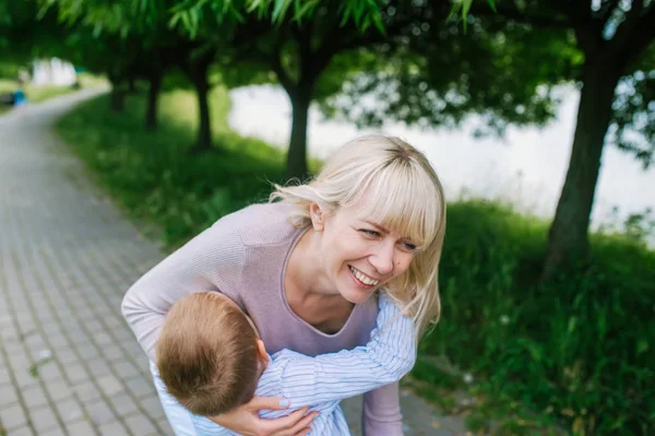 Милый веселый ребенок с матерью играть на открытом воздухе в парке — стоковое фото