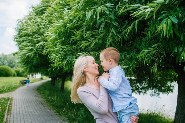 Mother plays with her son while walking in the park — Stock Photo, Image