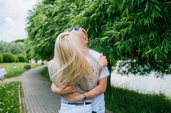 Liefdevolle man en vrouw tijdens een wandeling in een zomer stadspark — Stockfoto