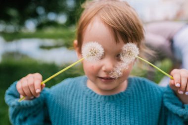 Gözler üzerinde karahindiba ile küçük kız gözlüklü. 
